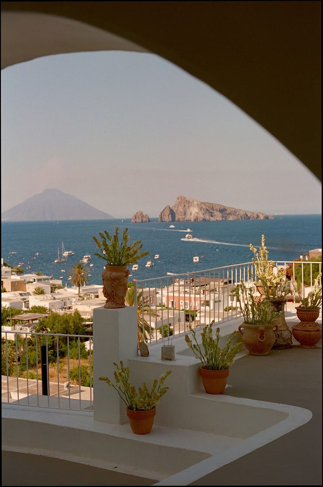 Stone arch of a Sorrento estate framing the gulf and Vesuvius