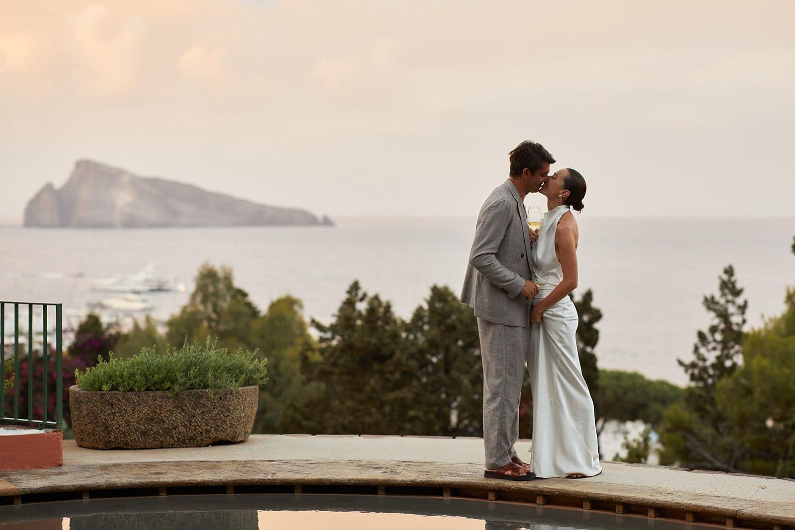 Couple kissing on a villa terrace with Capri on the horizon