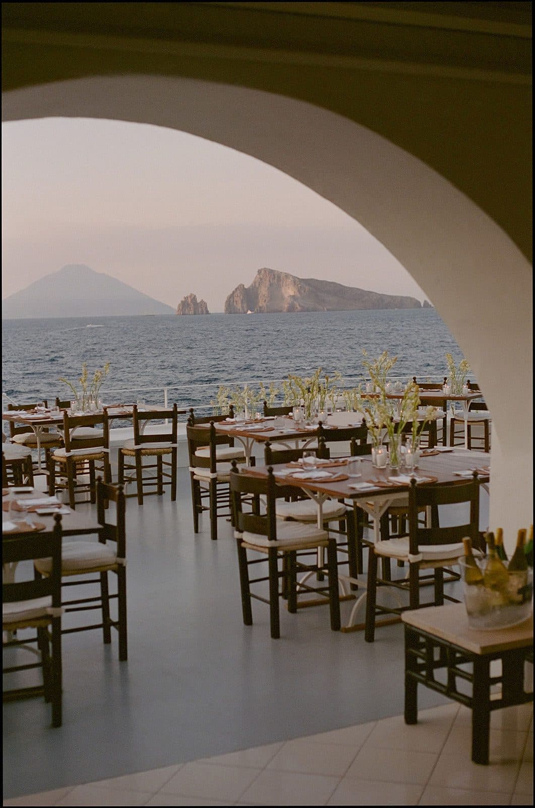 Terrace of a Sorrento hotel set for a wedding dinner, with the bay behind